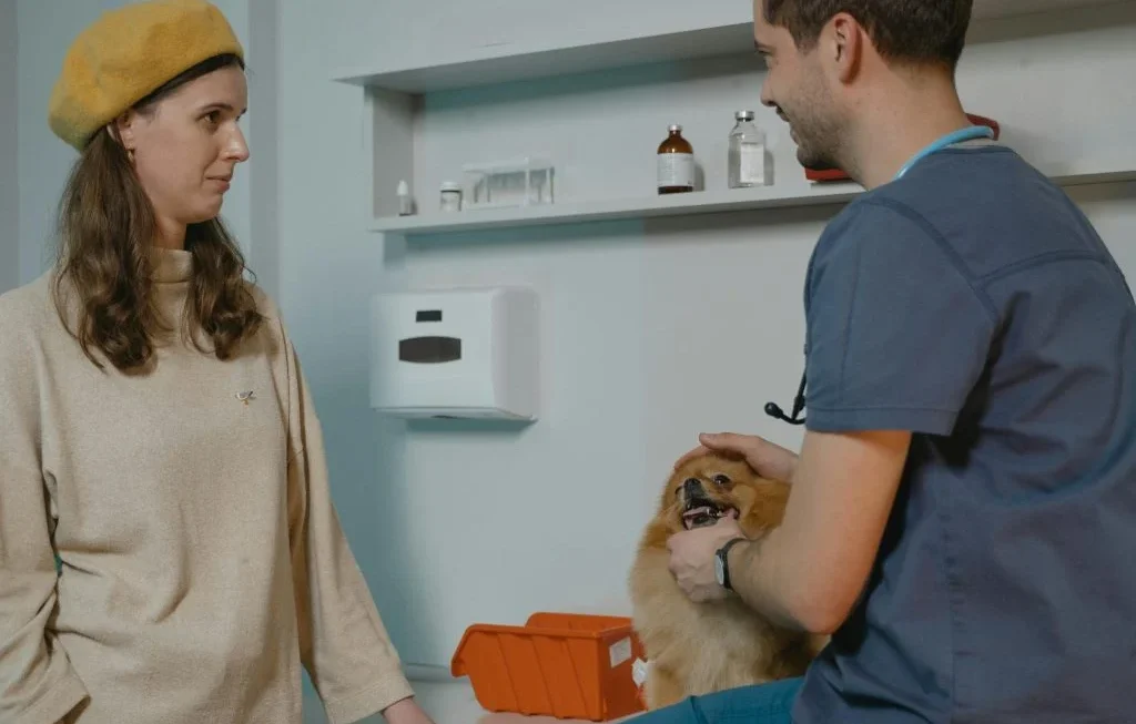 New pet owner holding a pet, with a book or guide in the background
