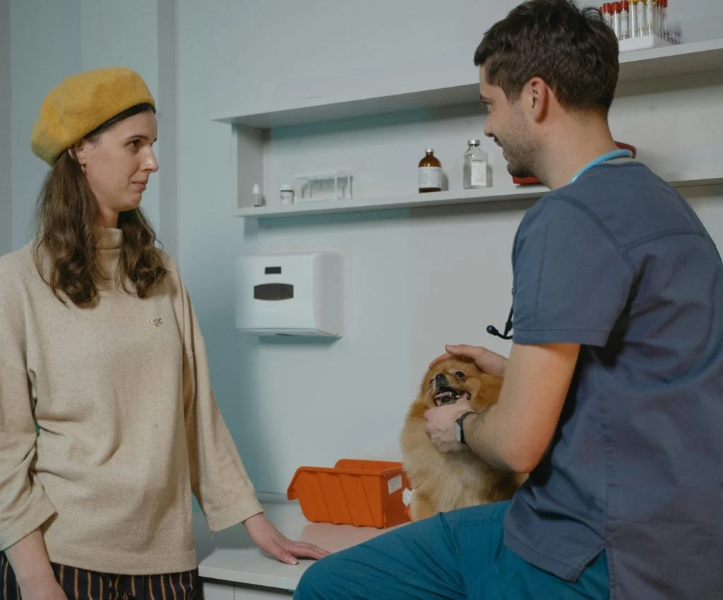 New pet owner holding a pet, with a book or guide in the background